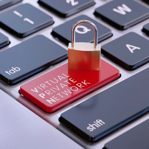 Napis "VPN" na przycisku klawiatury komputera, na którym stoi solidny zamek