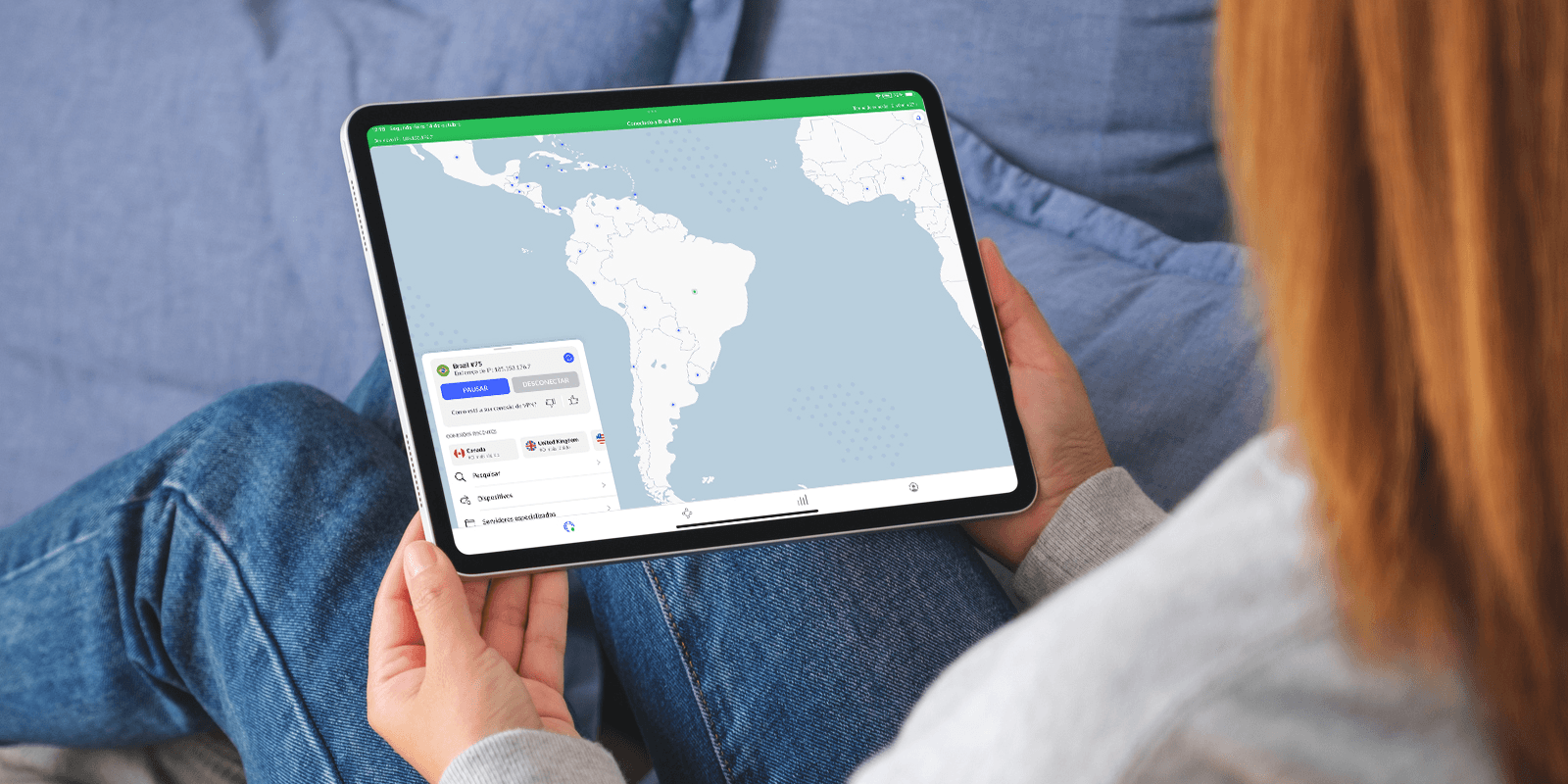 kobieta korzystająca z NordVPN na tablecie, leząc na niebieskiej kanapie - NordVPN działa na wielu urządzeniach